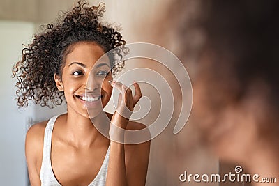 Young black woman applying skin cream Stock Photo