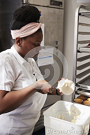 Young black woman at a bakery preparing cake frosting Stock Photo