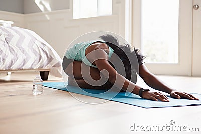 Young black woman practicing yoga in the cat stretch pose Stock Photo