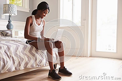 Young black woman ready for exercise, using laptop computer Stock Photo