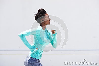 Young black woman running outside with earphones Stock Photo