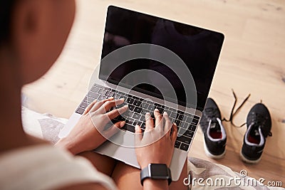 Young black woman using laptop computer, over-shoulder view Stock Photo