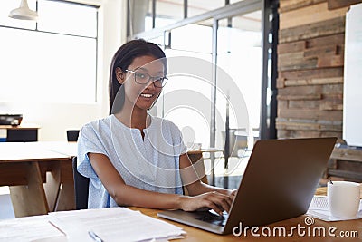 Young black woman using laptop in office smiling to camera Stock Photo