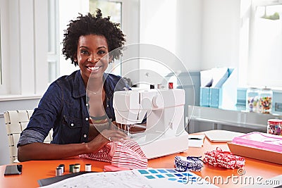 Young black woman using a sewing machine looking to camera Stock Photo