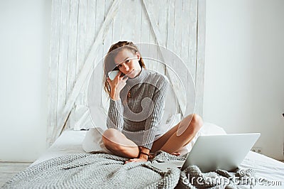 Young blogger or business woman working at home with social media, drinking coffee in early morning in bed Stock Photo