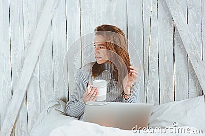 Young blogger or business woman working at home with social media, drinking coffee in early morning in bed Stock Photo