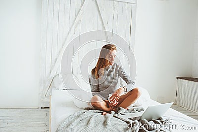 Young blogger or business woman working at home with social media, drinking coffee in early morning in bed Stock Photo