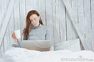 Young blogger or business woman working at home with social media, drinking coffee in early morning in bed Stock Photo