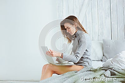 Young blogger or business woman working at home with social media, drinking coffee in early morning in bed Stock Photo