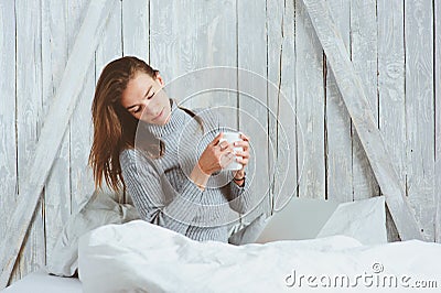 Young blogger or business woman working at home with social media, drinking coffee in early morning in bed Stock Photo