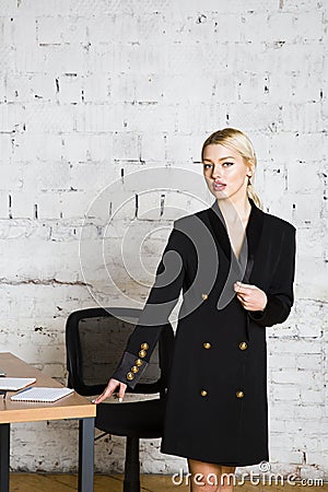 Young blond beauty businesswoman sitting at a office table with laptop, notebook and glasses in suit. Business concept. Stock Photo