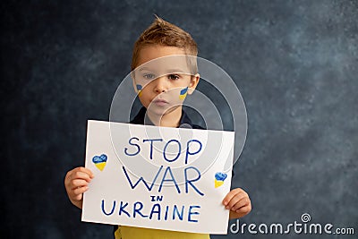 Young blond child, holding sign in support to peace, no war wanted, kid wishing peaceful life Stock Photo