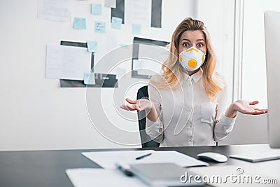 Young blond surprised woman manager looks scared working in office during Covid-19 epidemy, virology concept Stock Photo