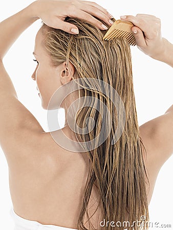 Young Blond Woman Combing Wet Hair Stock Photo