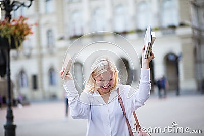 Blond woman on street carrying books Stock Photo