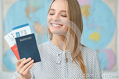 Young blonde female traveler in a tour agency holding passports close-up Stock Photo