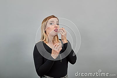 Young blonde girl in black jacket terrified woman shows emotions of fear Stock Photo