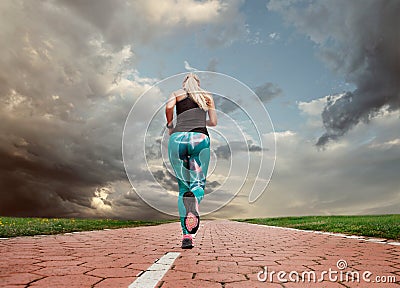 Young blonde girl evening jogging with great cloudscape Stock Photo