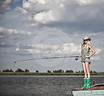 Young blonde girl fishing in lake Stock Photo