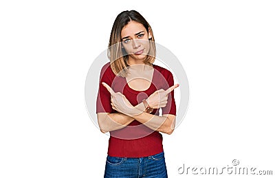 Young blonde girl wearing casual clothes pointing to both sides with fingers, different direction disagree Stock Photo