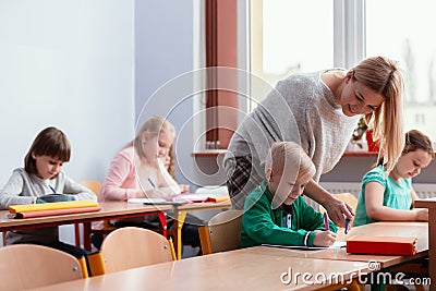 Blonde haired teacher with children in the classroom Stock Photo