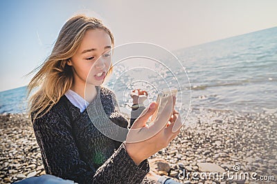 Happy relaxed young woman meditating in a yoga pose at the beach Stock Photo