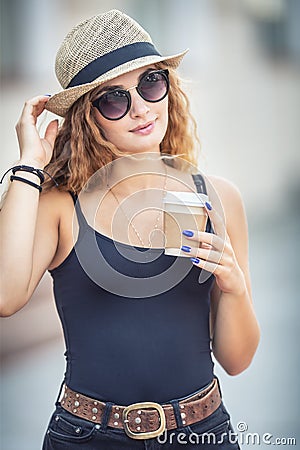 Young blonde woman drinking coffee somewhere in the city streets Stock Photo