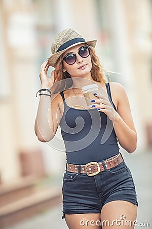 Young blonde woman drinking coffee somewhere in the city streets Stock Photo