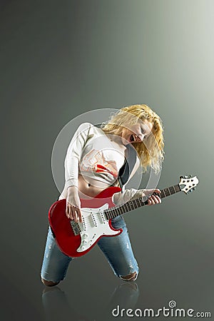 young blonde woman with a guitar sings a rock song Stock Photo