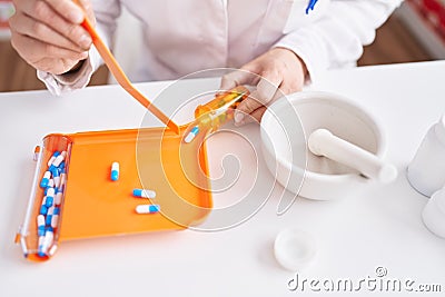 Young blonde woman pharmacist oranizing pills dose at pharmacy Stock Photo