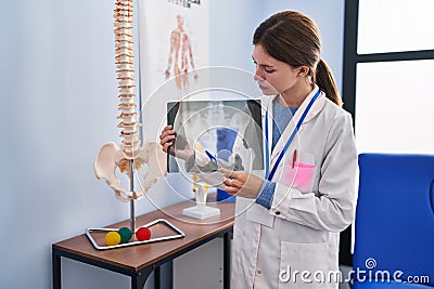 Young blonde woman physiotherapist looking xray with serious face at rehab clinic Stock Photo