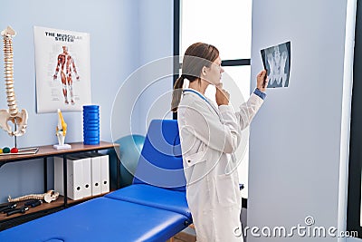 Young blonde woman physiotherapist looking xray thinking at rehab clinic Stock Photo