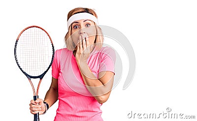 Young blonde woman playing tennis holding racket covering mouth with hand, shocked and afraid for mistake Stock Photo
