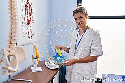 Young blonde woman podiatrist holding insole at clinic Stock Photo