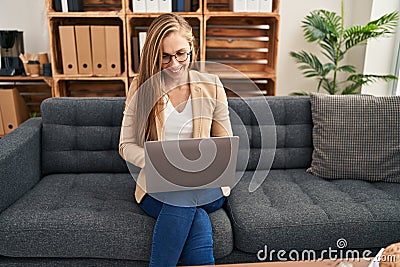 Young blonde woman psychologist using laptop at psychology clinic Stock Photo