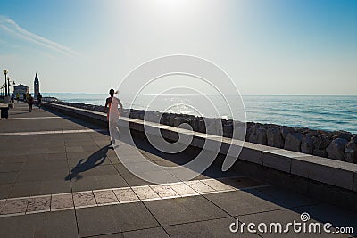 A young woman runs along the sea Editorial Stock Photo
