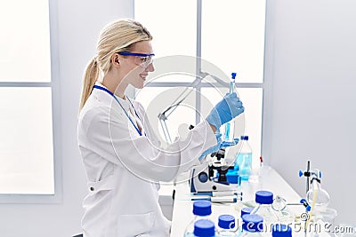 Young blonde woman scientist analysing test tubes at laboratory Stock Photo