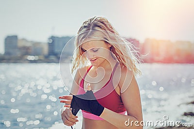 Young blonde woman wrapping hands outdoor Stock Photo