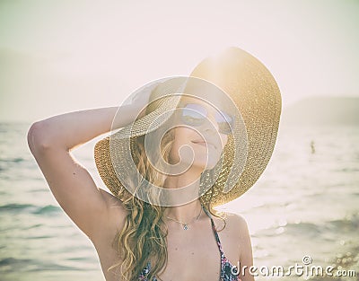 Young blondy girl in sunglasses and straw hat at the beach Stock Photo