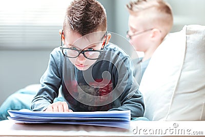 Young blue-eyed boy with upswept hairstyle relaxing reading Stock Photo