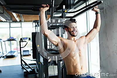 Young bodybuilder training in gym on machine Stock Photo