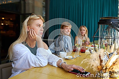 Bored caucasian woman sits alone at restaurant Stock Photo