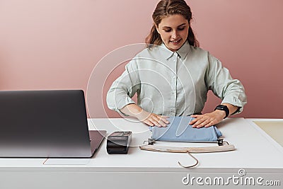 Young boutique owner straightens clothes on counter Stock Photo