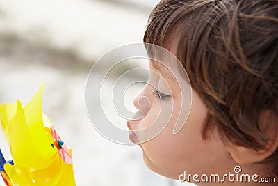 Young boy blowing on windmill Stock Photo