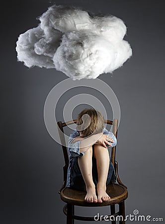 Young boy child sitting on chair with cloud above his head Stock Photo