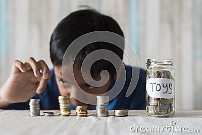 Young boy counting his coins/savings to buy dream toys. Stock Photo