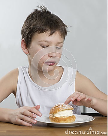 Young boy with cream bun Stock Photo