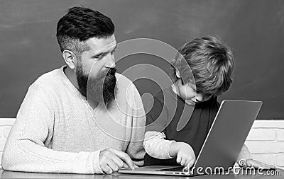 Young boy doing his school homework with his father. Teacher helping young boy with lesson. Little students. Daddy and Stock Photo