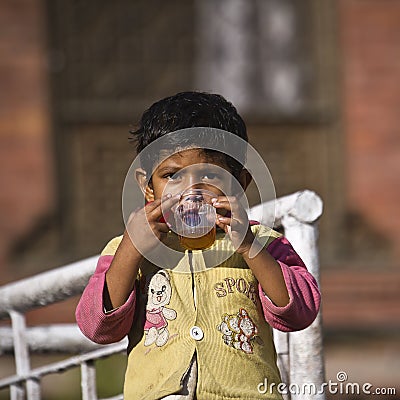 A young boy is drinking a cup of tea Editorial Stock Photo