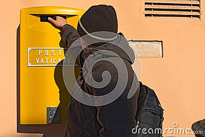 The young boy drops a postcard in a mailbox in the Vatican. Rome. Italy Editorial Stock Photo
